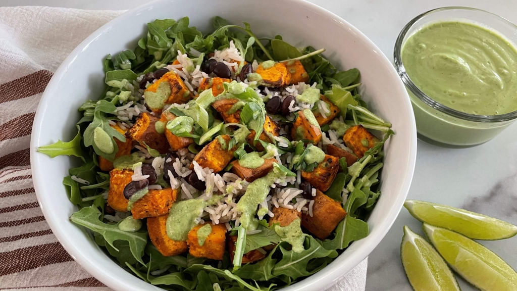 Side view of a white bowl filled with Warm Roasted Sweet Potato Salad